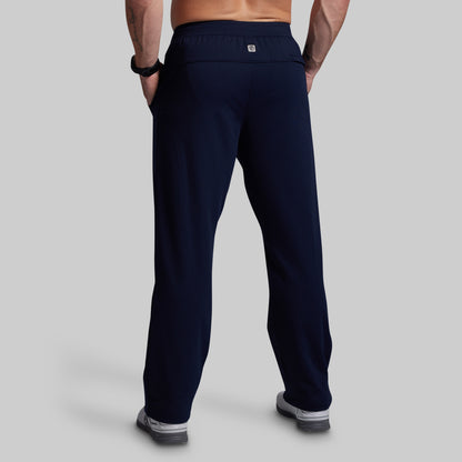 Person wearing navy blue athletic pants on a gray background