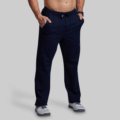 Person wearing navy blue pants on a gray background