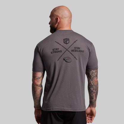 Man wearing a gray t-shirt with motivational text and logo on the back against a plain background