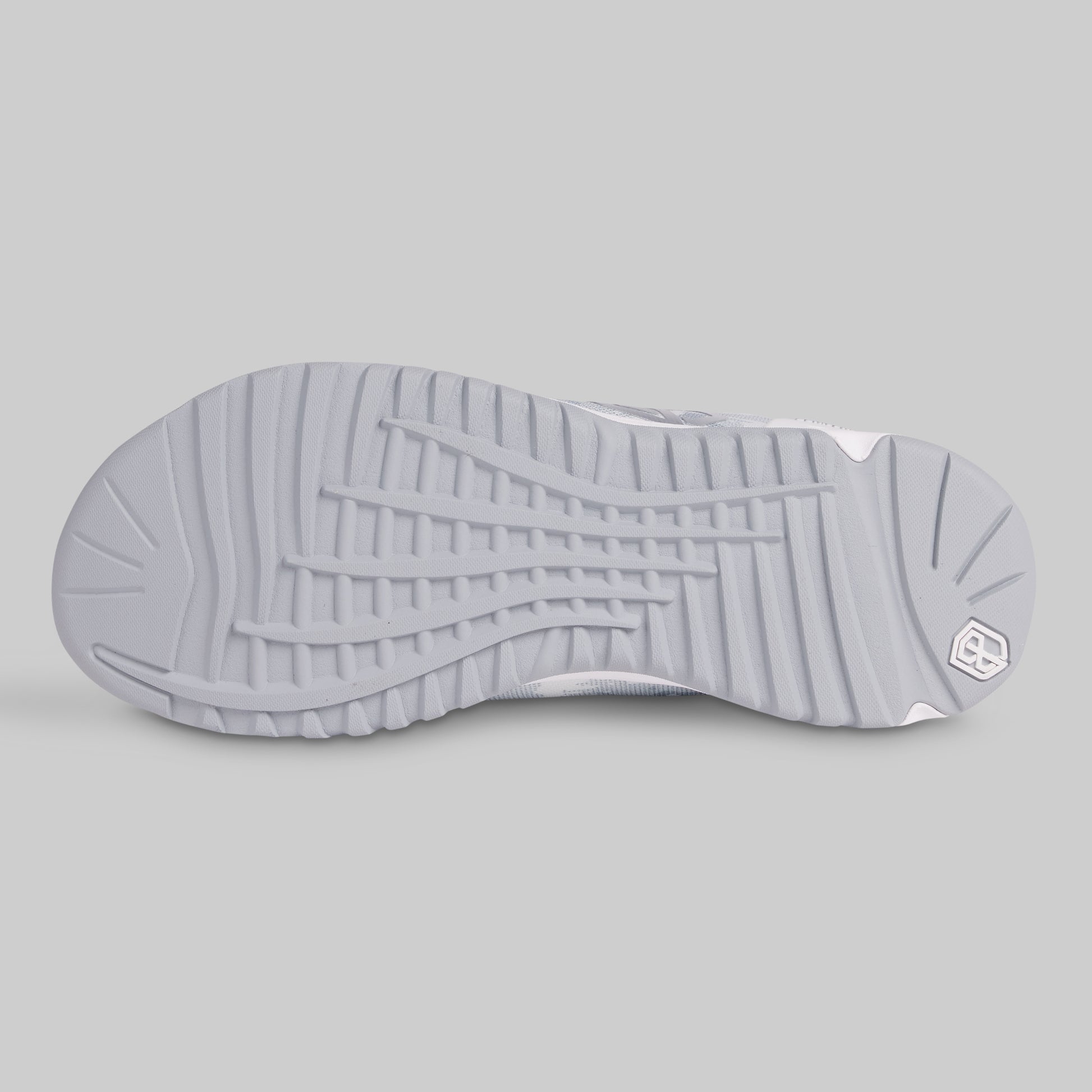 Close-up of a gray sneaker sole with a brand logo on a light gray background