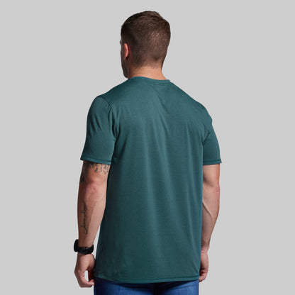Man wearing a green t-shirt against a gray background