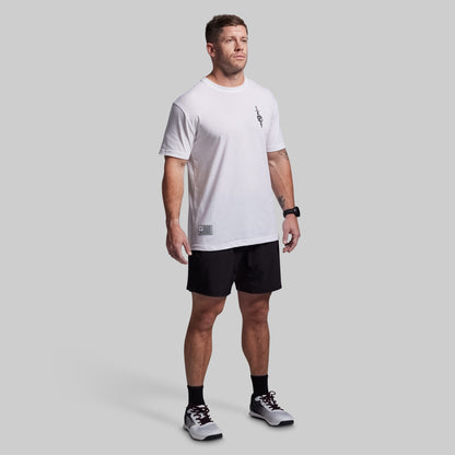 Man wearing a white t-shirt and black shorts on a gray background