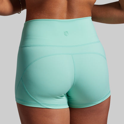 Turquoise athletic shorts worn by a person on a plain background