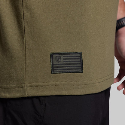 Close-up of a green t-shirt with a patch featuring an American flag design.