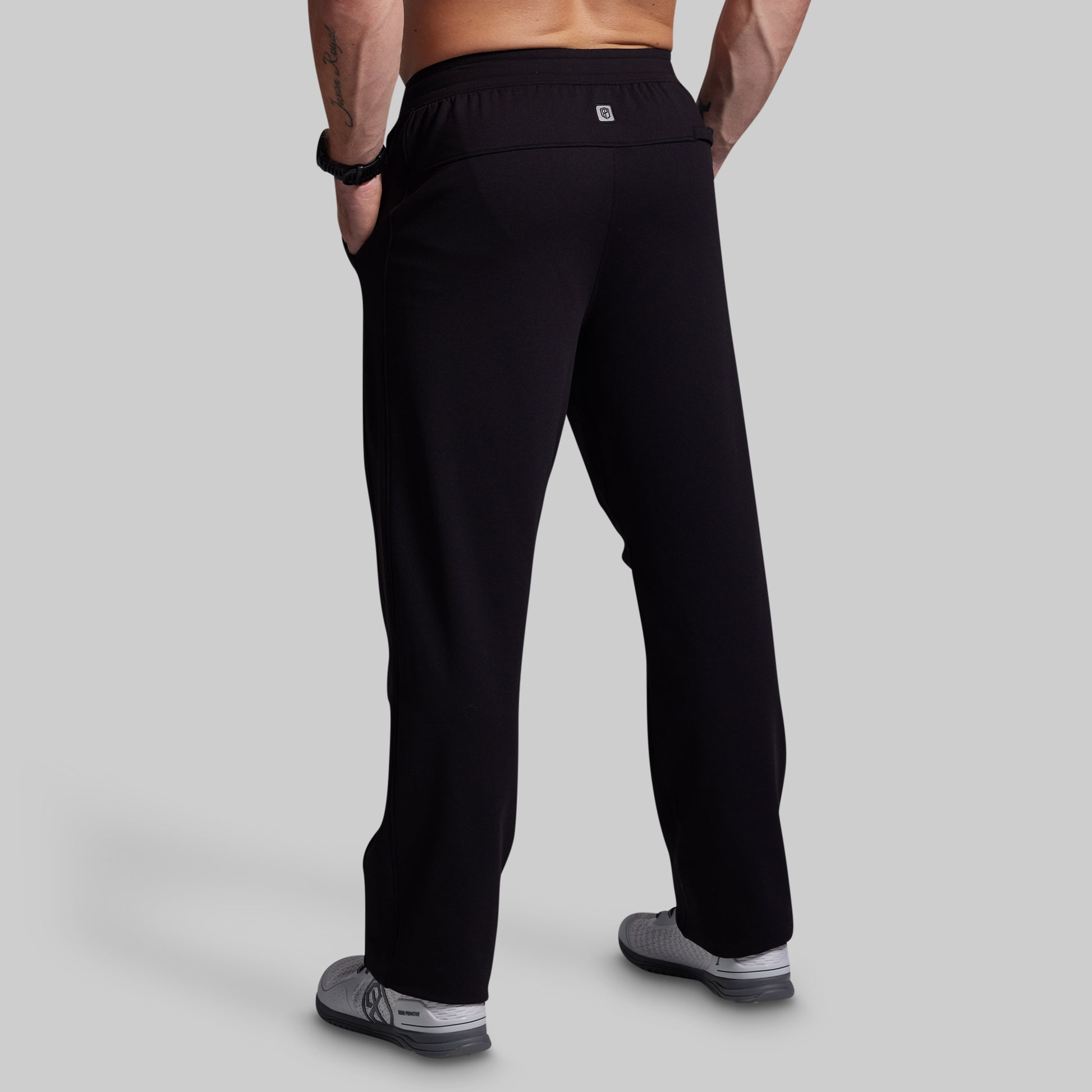Person wearing black pants on a gray background