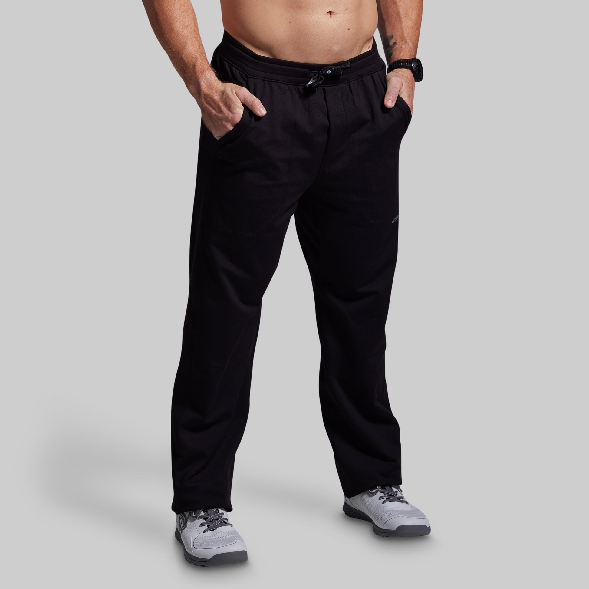 Person wearing black pants on a gray background