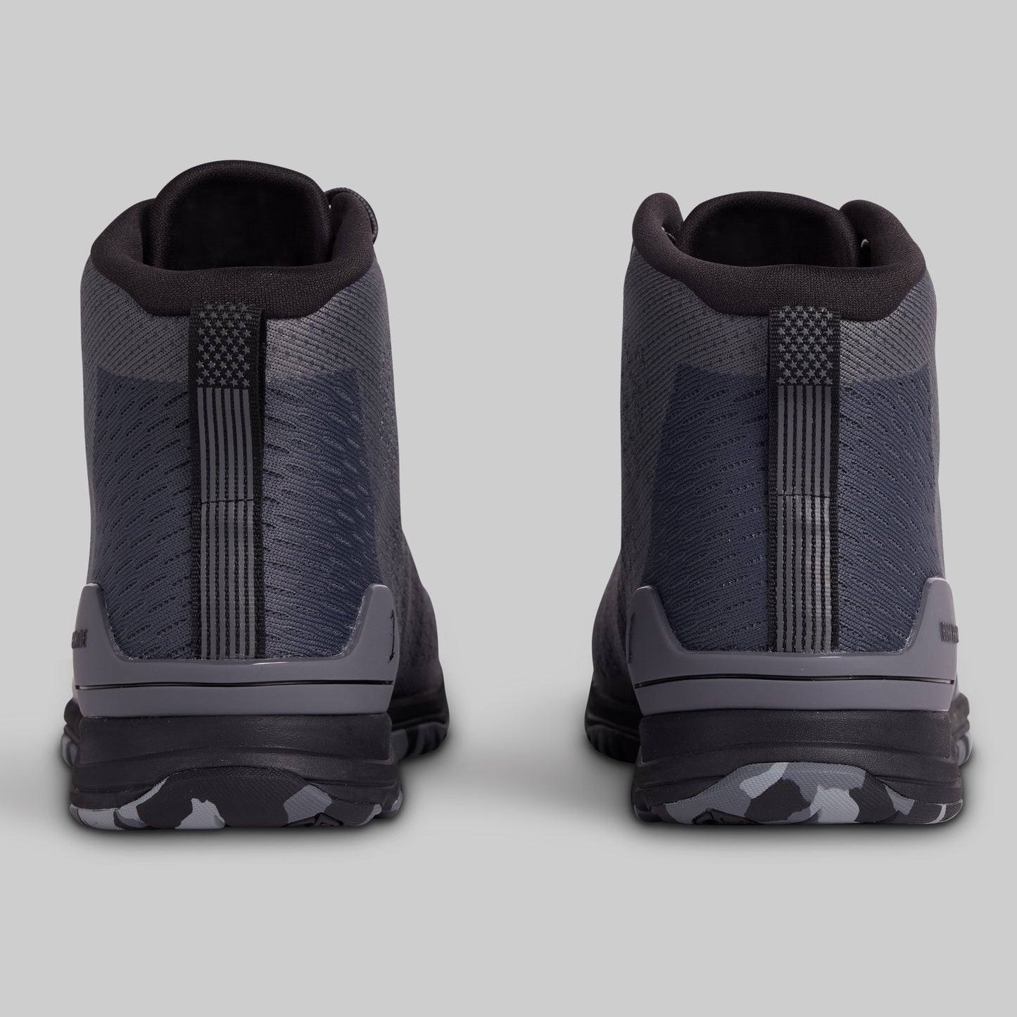 Pair of black and gray high-top sneakers on a light gray background