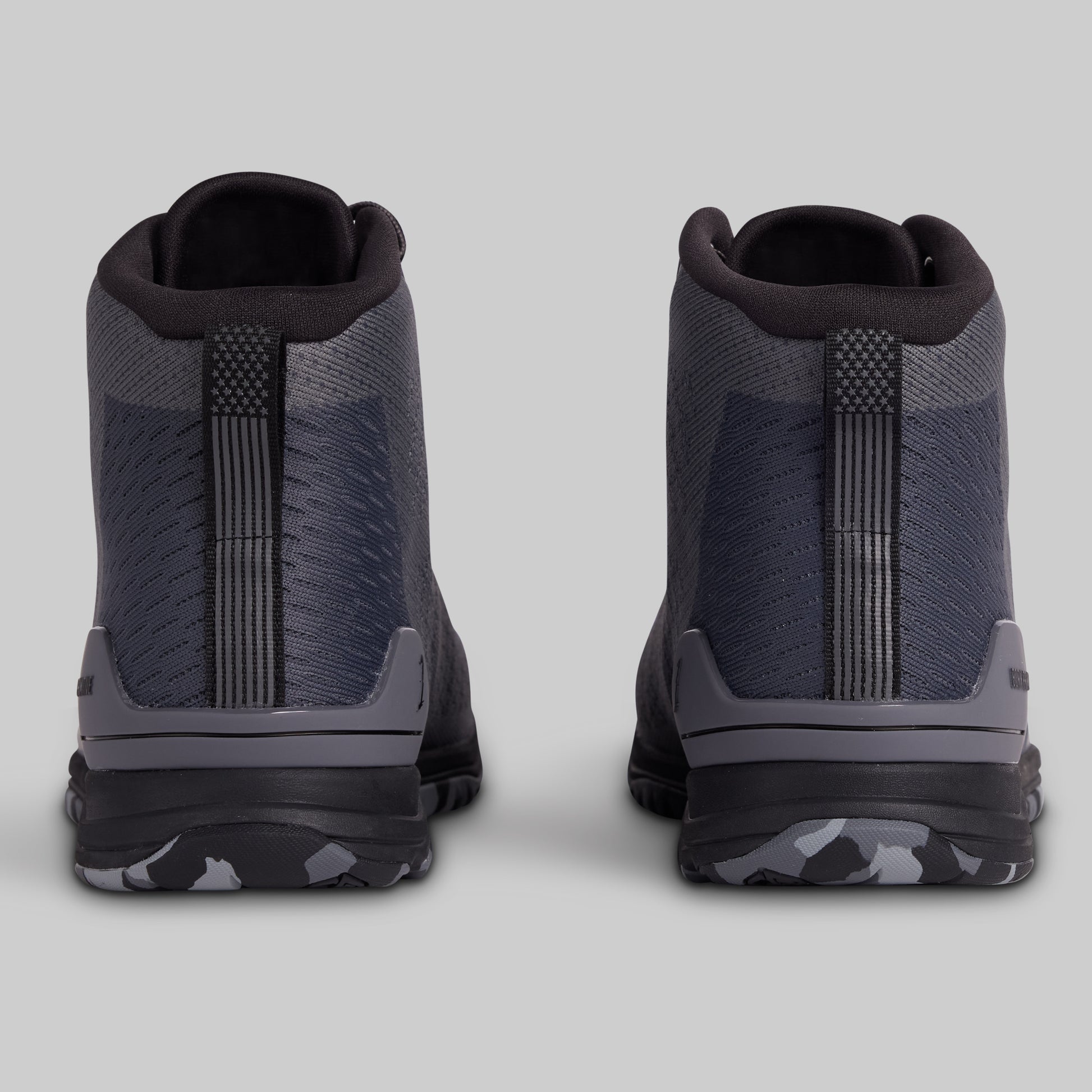 Pair of black and gray high-top sneakers on a light gray background