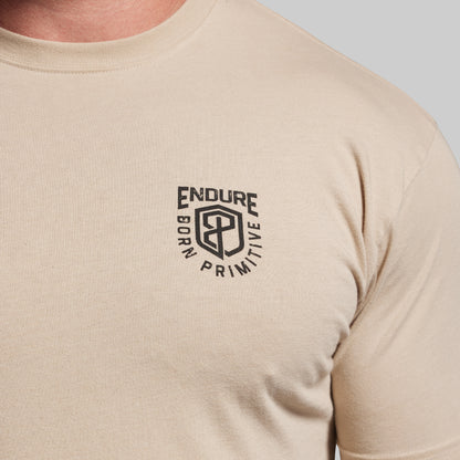 Beige t-shirt with a black logo on a light gray background
