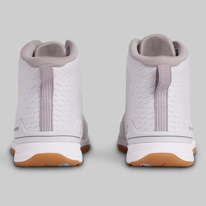 White sneakers with brown soles on a light gray background