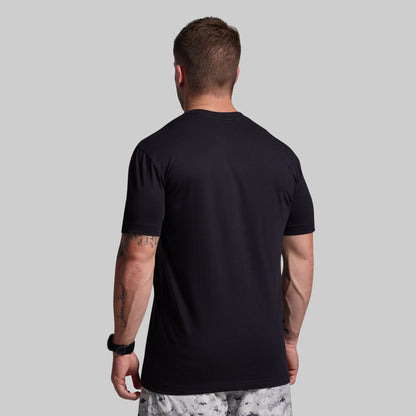 Man wearing a black t-shirt against a gray background