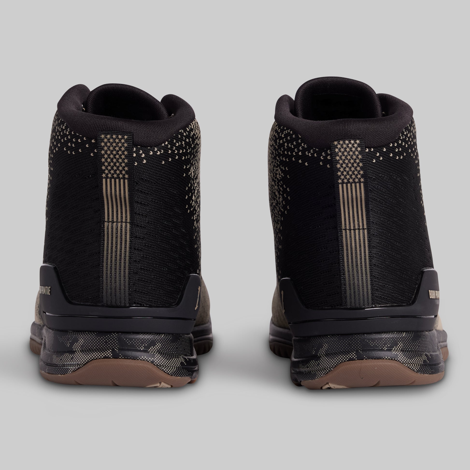 Black high-top sneakers with decorative elements on a light gray background
