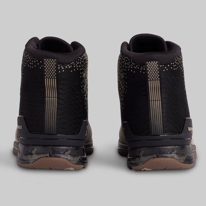 Black high-top sneakers with decorative elements on a light gray background