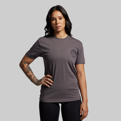 Woman wearing a gray t-shirt with a logo on a gray background