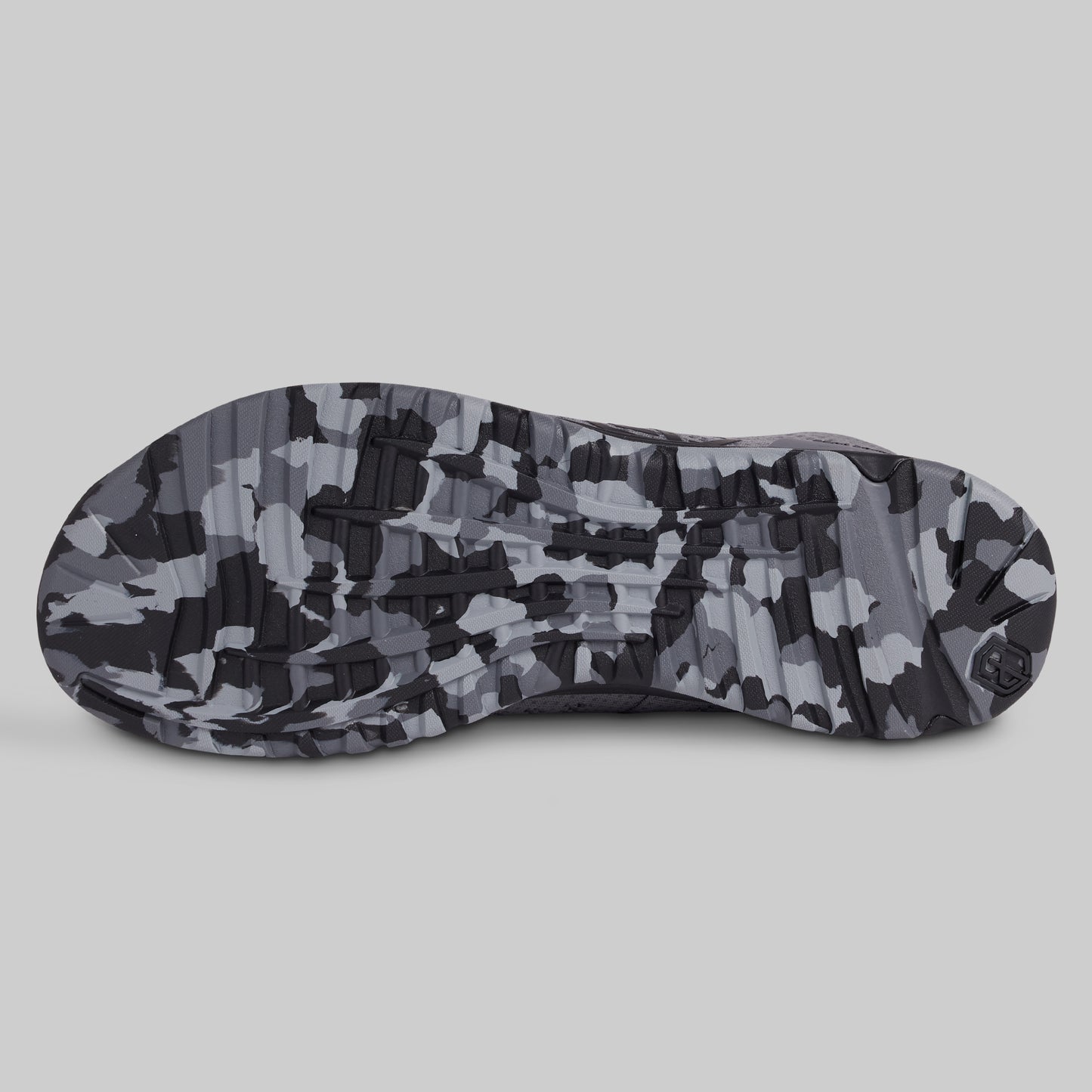 Camouflage-patterned sole of a shoe on a light gray background
