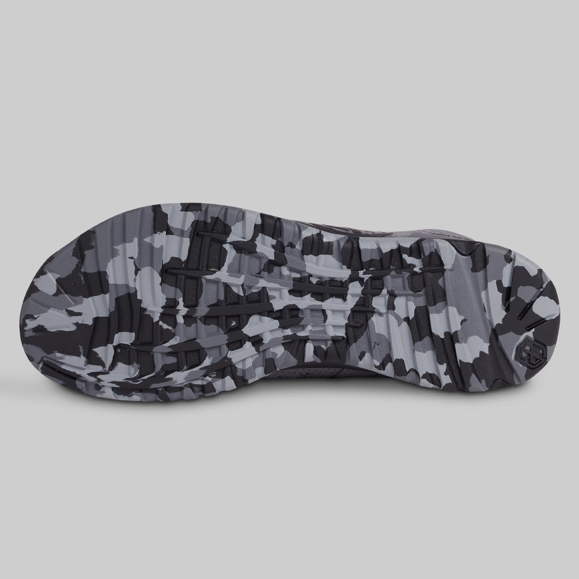 Camouflage-patterned sole of a shoe on a light gray background