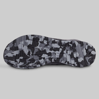 Camouflage-patterned sole of a shoe on a light gray background