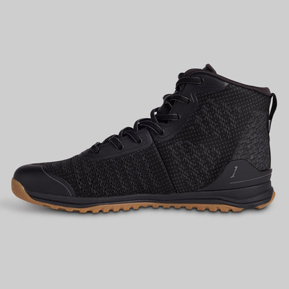 Black high-top sneaker with brown sole on a gray background