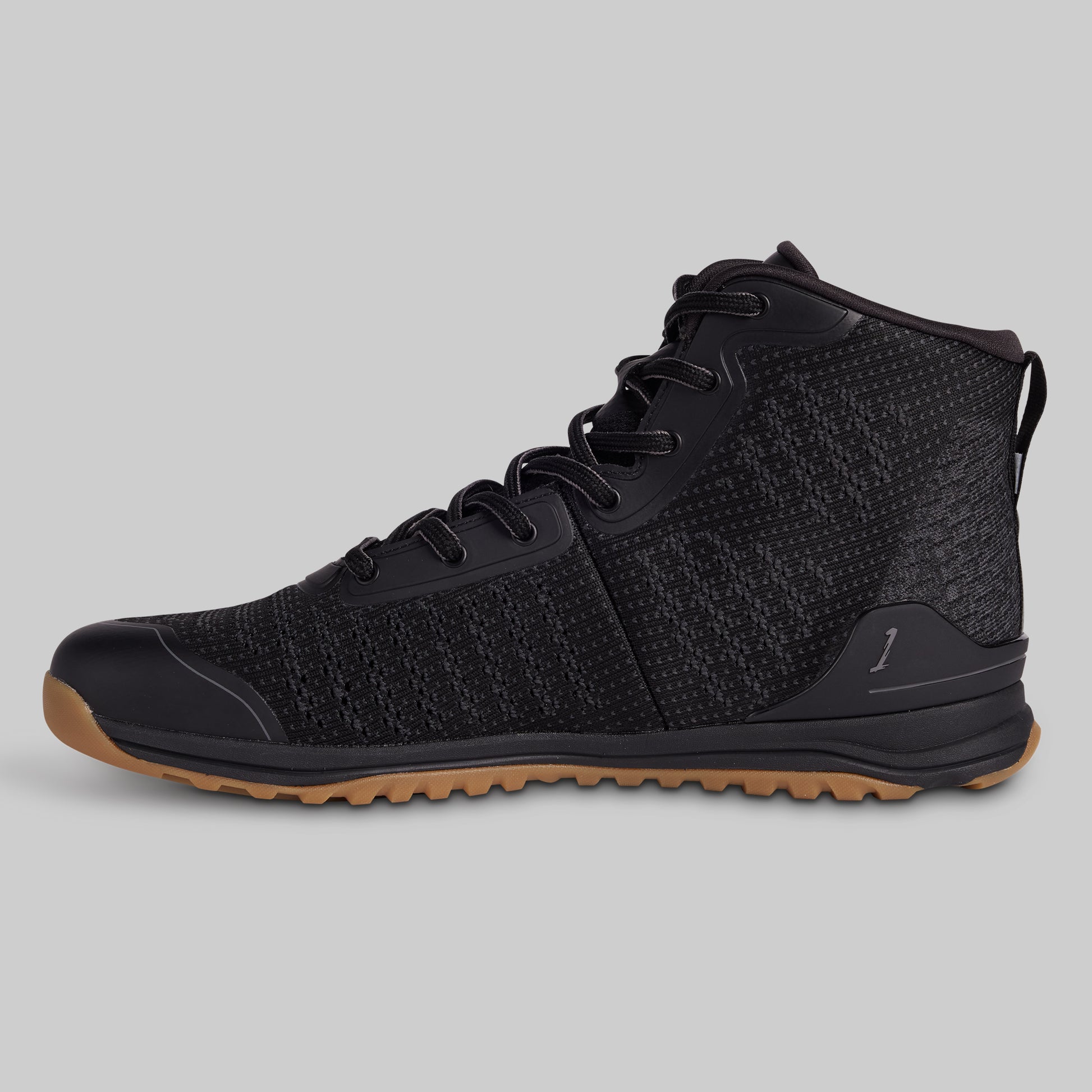 Black high-top sneaker with brown sole on a gray background