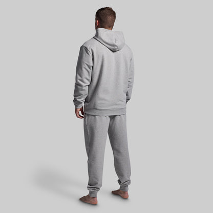 Person wearing a gray tracksuit against a plain background