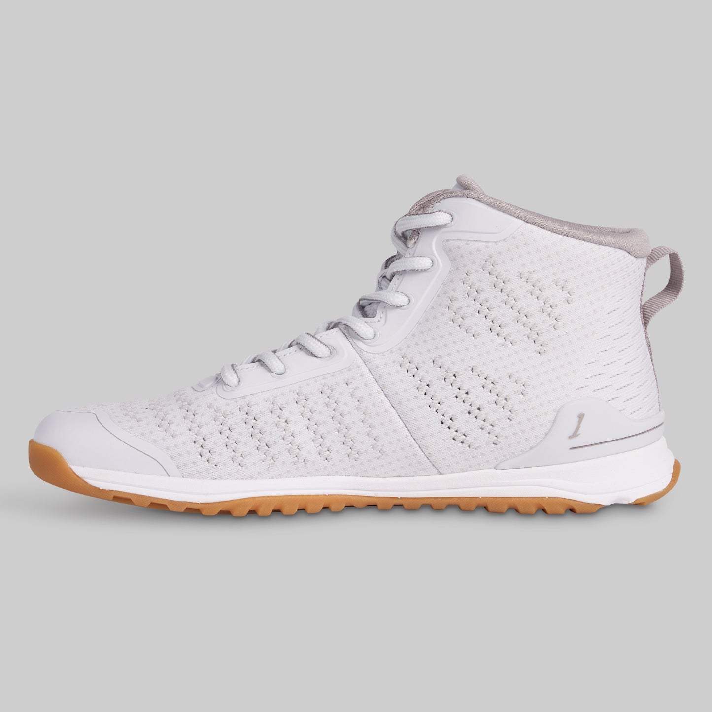 White sneaker with brown sole on a gray background