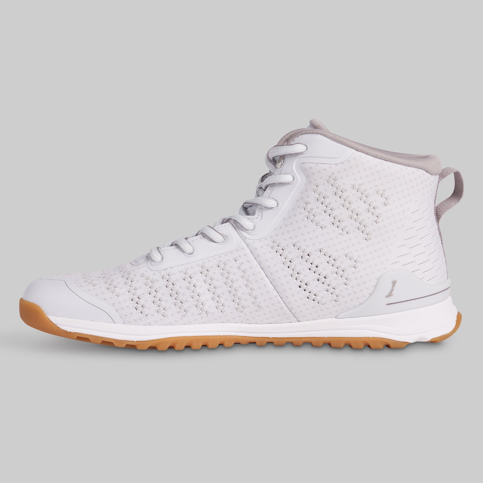 White sneaker with brown sole on a gray background