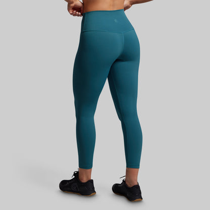 Teal leggings worn by a person on a gray background