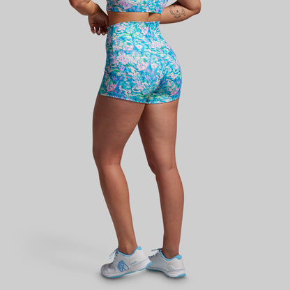 Person wearing a colorful floral sports outfit on a gray background