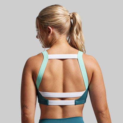 Woman wearing a sports bra and leggings on a gray background