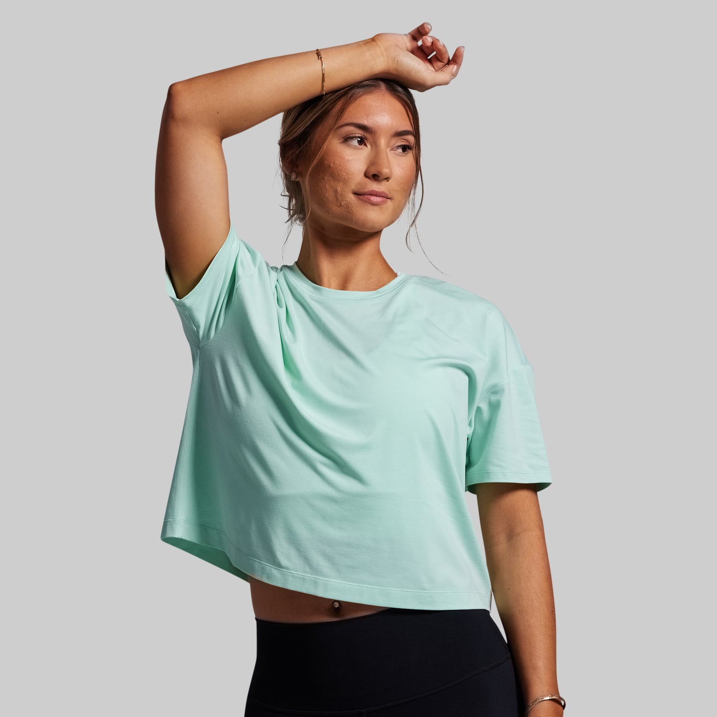 Person wearing a light blue t-shirt on a gray background