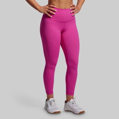 Person wearing bright pink leggings on a gray background
