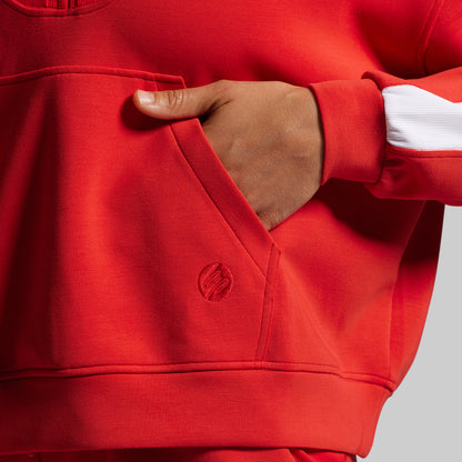 Red sweatshirt with a brand logo on a gray background