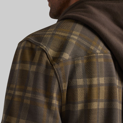 Close-up of a person wearing a brown and tan plaid hooded flannel 