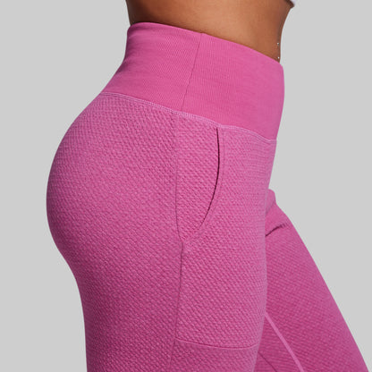 Close-up of pink textured leggings on a plain background