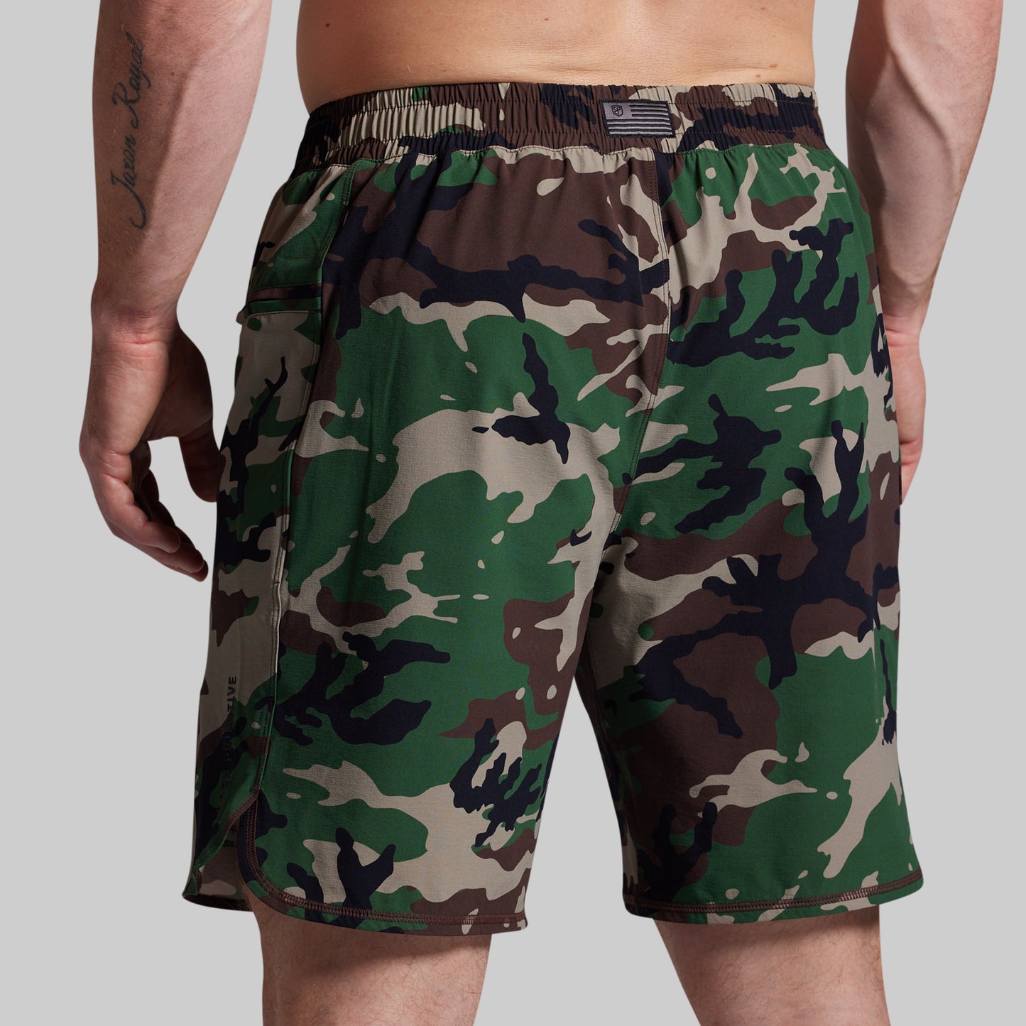 Camouflage shorts worn by a person on a plain background