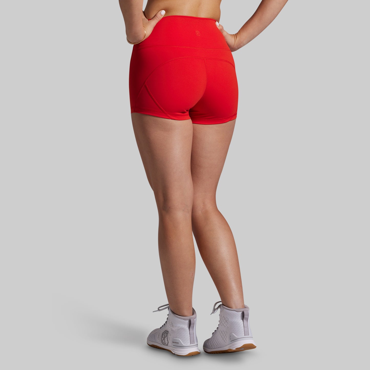 Person wearing red athletic shorts on a gray background
