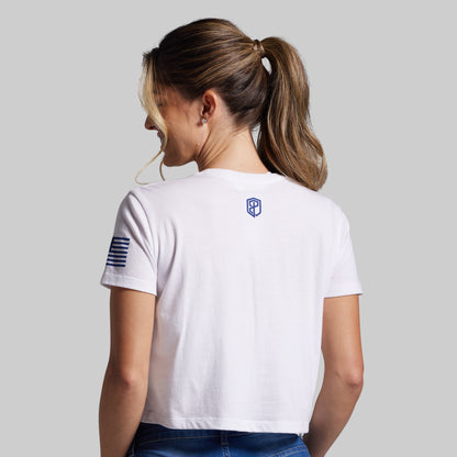 Woman wearing a white t-shirt with a logo on the back against a plain background