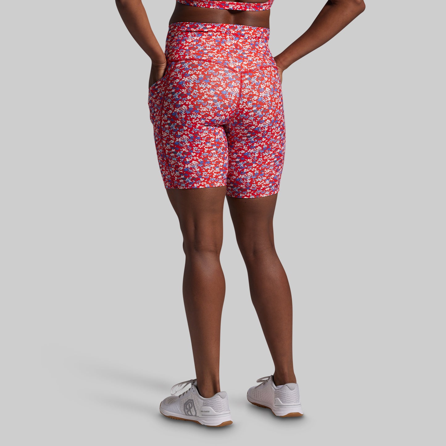 Person wearing red patterned shorts on a gray background