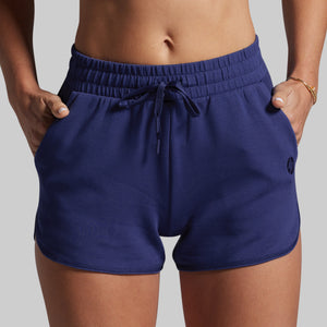 Navy blue shorts with a drawstring on a gray background