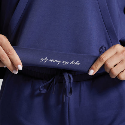 Navy blue garment with text on waistband held by hands