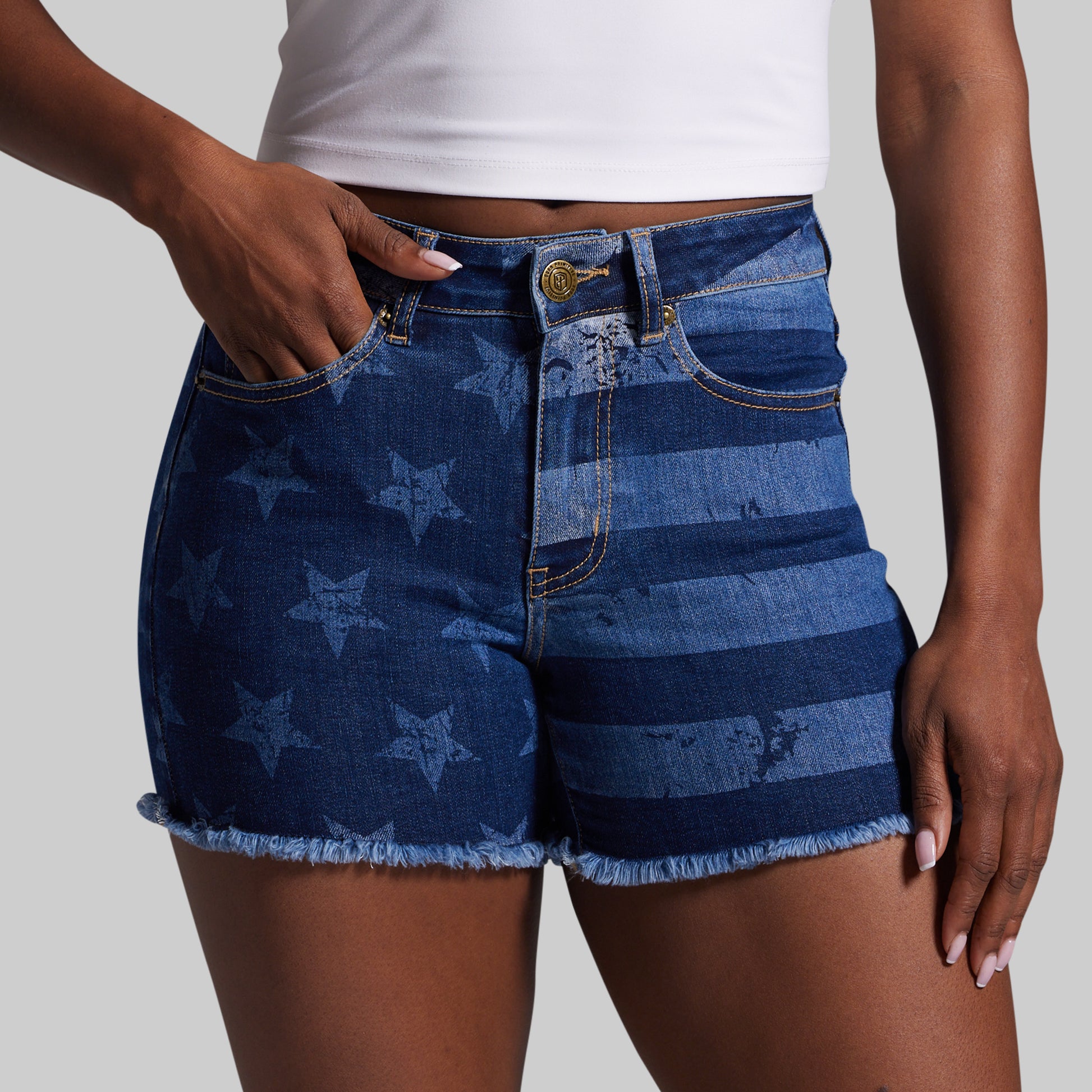 Blue denim shorts with American flag pattern worn by a person on a plain background
