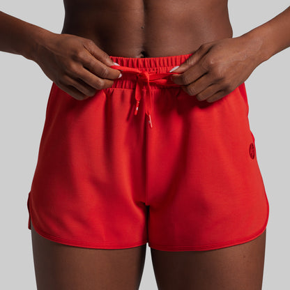 Person wearing red shorts with a plain background