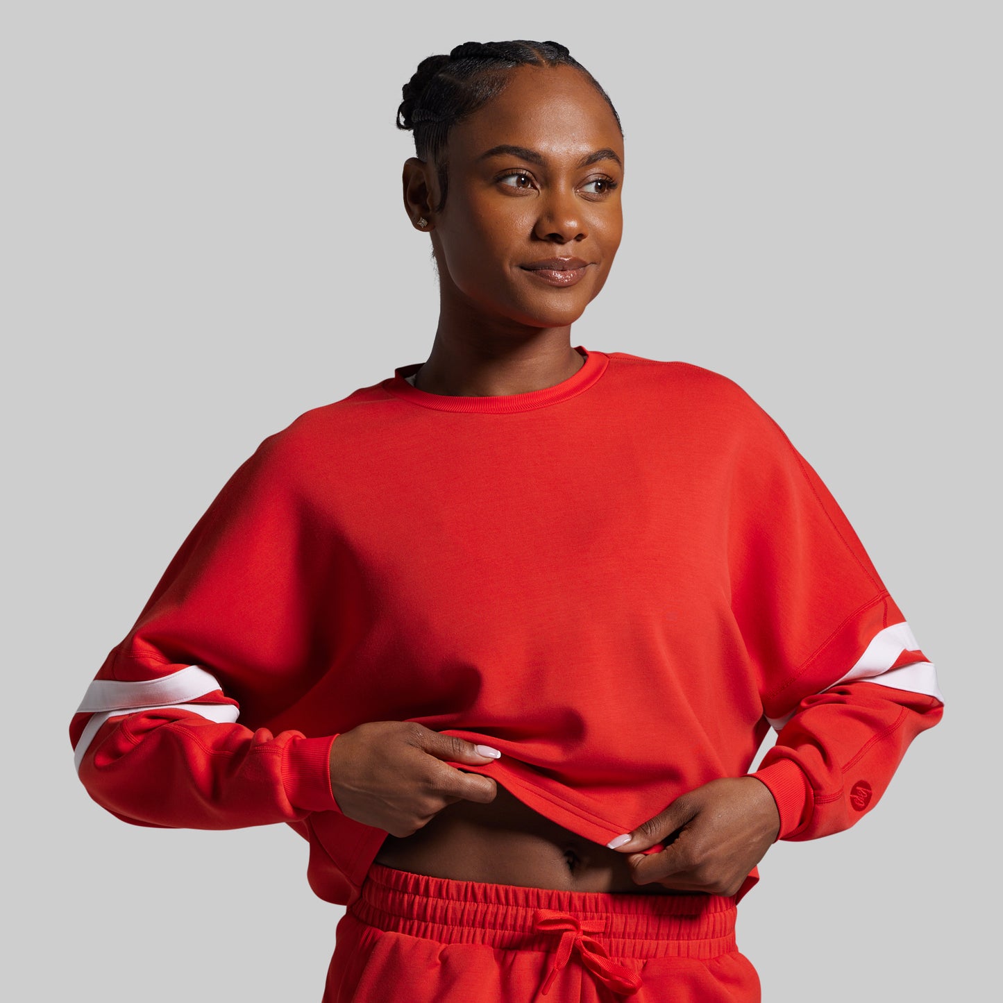 Woman wearing a red outfit with white stripes on a gray background