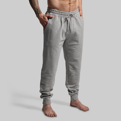 Person wearing gray sweatpants on a plain background