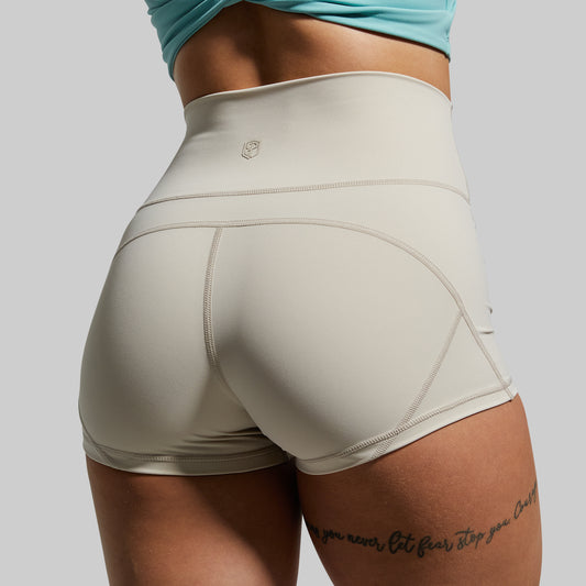 Beige athletic shorts worn by a person on a plain background