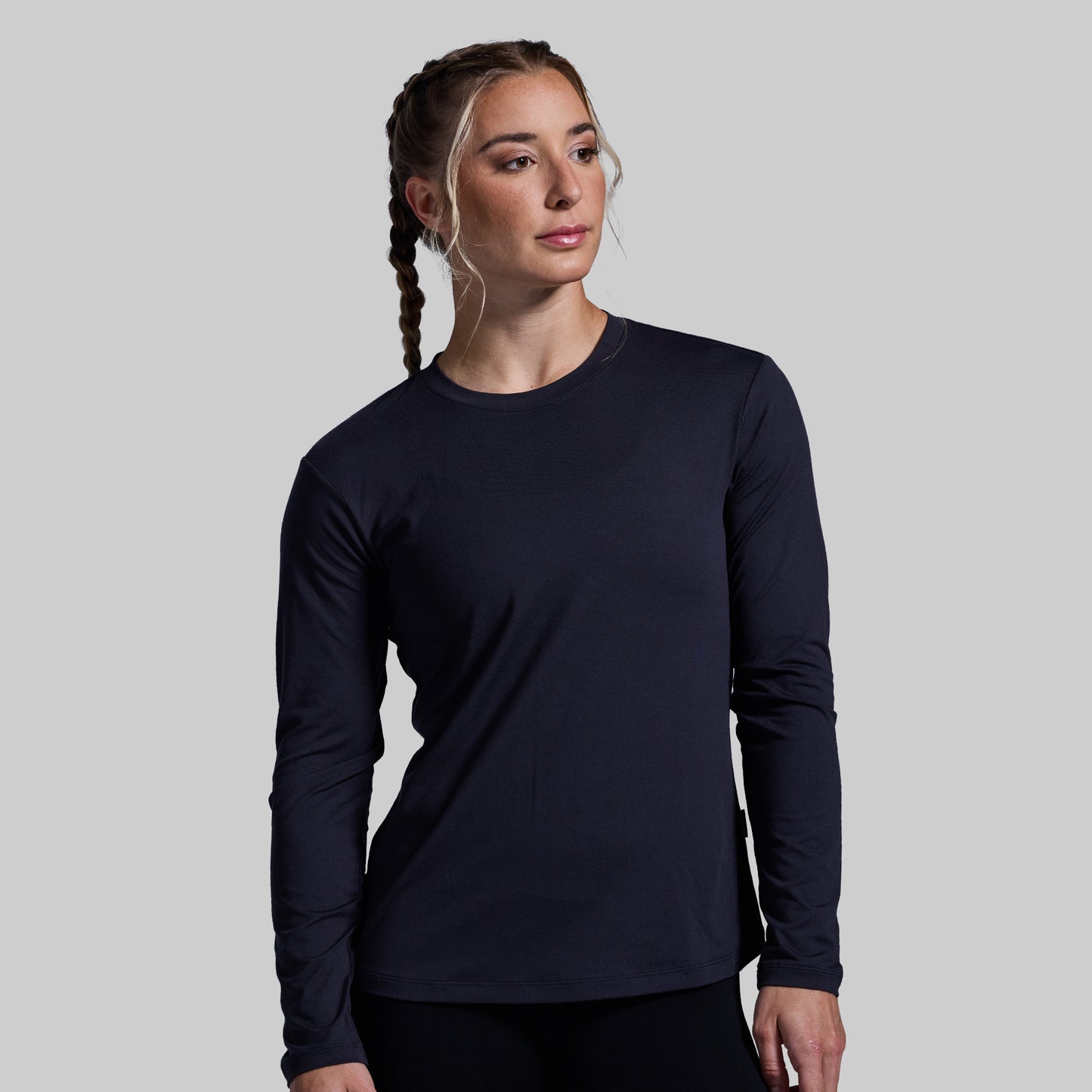 Woman wearing a black long-sleeve shirt against a plain background