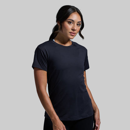 Woman wearing a black t-shirt against a plain background