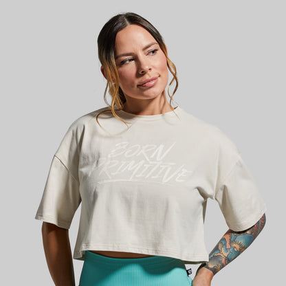 Woman wearing a white cropped t-shirt with text on a gray background