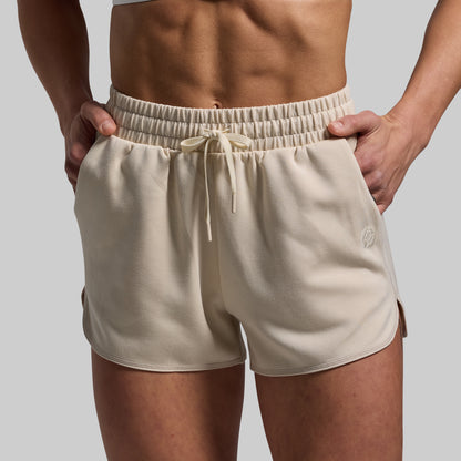 Beige shorts worn by a person on a plain background