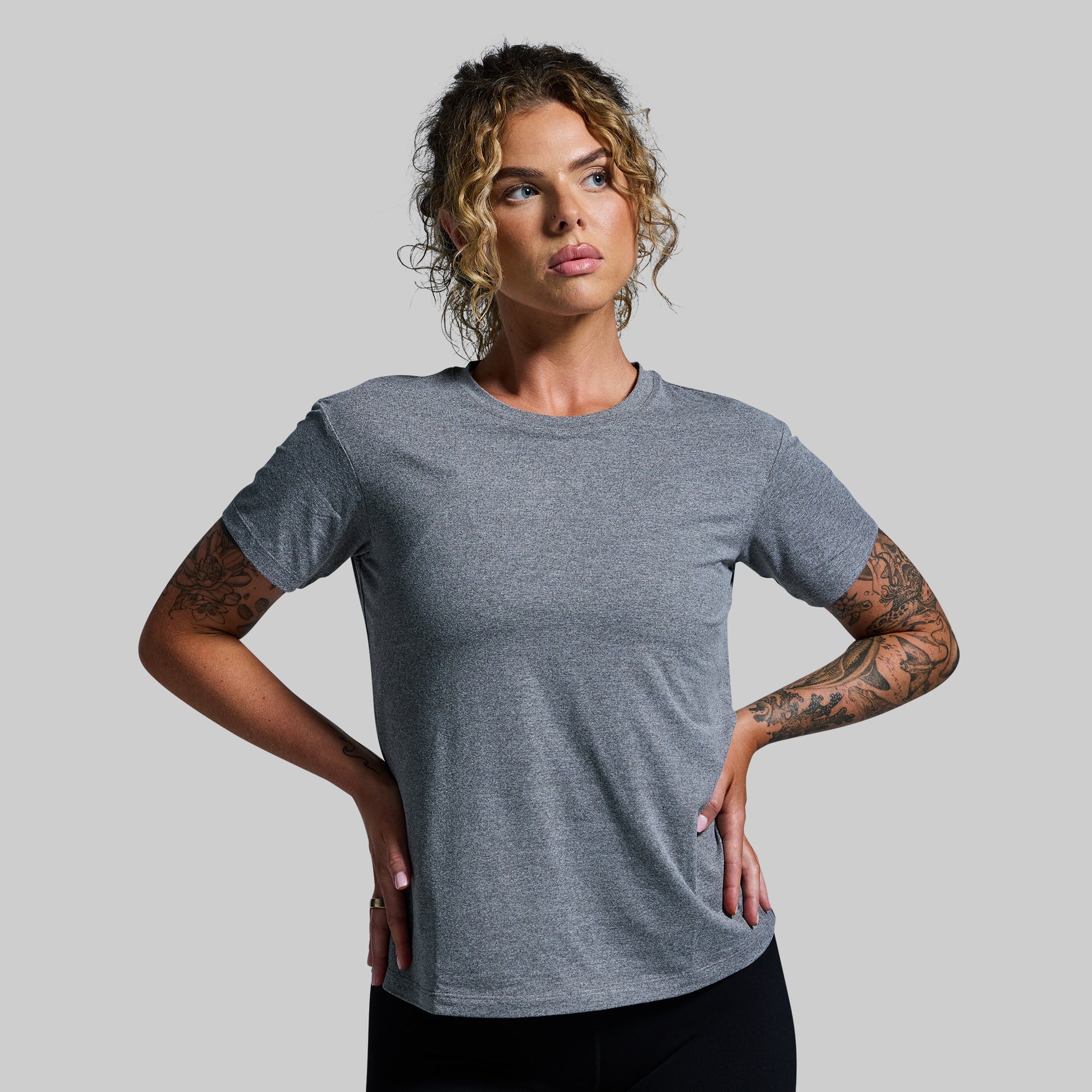 Woman wearing a gray t-shirt against a plain background